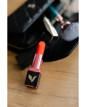 Pomadka - Cichy wibrator na tle damskiej torebki